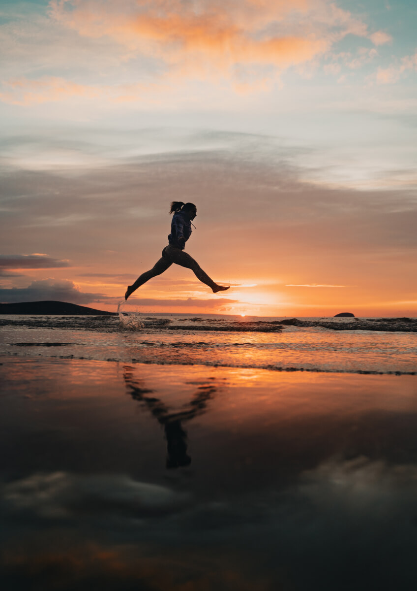 Person jumping at sunset